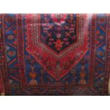 Persian wool runner, the central medallion in dark ink colour upon a red and blue alternating