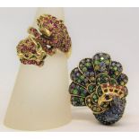 Two 9ct novelty gem set rings modelled as a twin headed leopard, size N and a peacock, size O, 17.4g