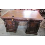 A Victorian oak partners desk, each side fitted with three drawers and two cupboards, with carved