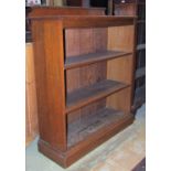 An Edwardian oak floorstanding open bookcase with shallow raised back over two adjustable shelves