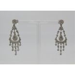 Two pairs of 18ct white gold diamond set drop earrings; one chandelier pair and the other of trefoil