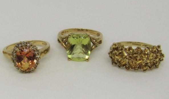 Three 9ct dress rings comprising an orange topaz example, yellow quartz example and an orange gem