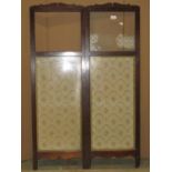 An Edwardian two fold fireside screen, the lower section enclosed by material panels, the upper