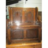 A good quality old English style oak settle with distressed finish, hinged box seat and winged