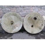 Two good carved natural stone millstones 70 cm in diameter approx x 15 cm thick, together with two