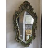 A decorative shield shaped wall mirror, the moulded plaster frame with scrolling acanthus detail and