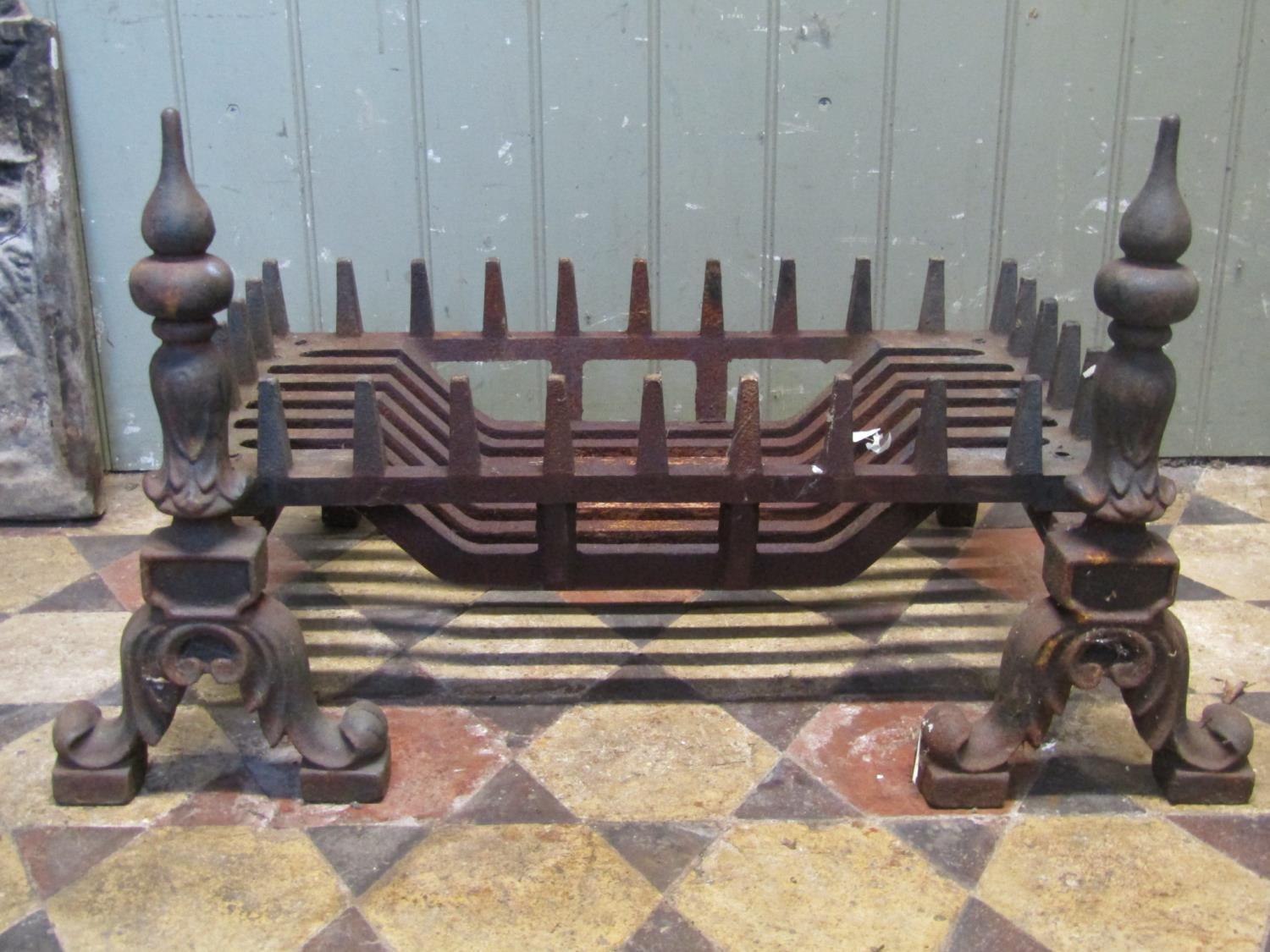 A cast iron fire grate of rectangular form and loose dogs with foliate detail, the basket 60 cm x 33