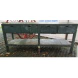 A vintage green painted wooden work bench, fitted with four frieze drawers, raised on square cut