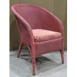 A Lloyd Loom tub chair with sprung upholstered seat and pink colourway
