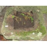 A weathered natural stone drain cap/surround with canted corners, 67 cm square x 10 cm thick approx