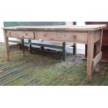 A Victorian pine work table with boarded top over two frieze drawers raised on square cut and