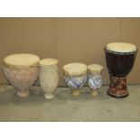 A carved Djembe African drum, together with two bongos with skin covers (varying design)