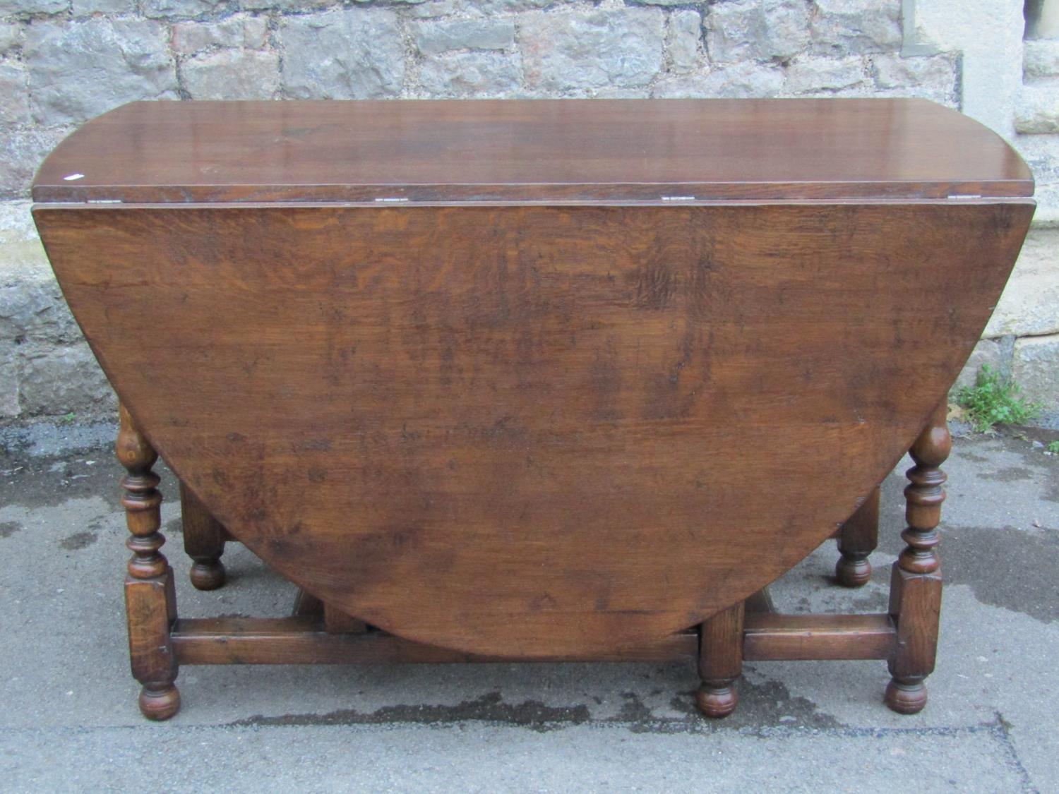 A good quality reproduction old English style oak oval drop leaf gateleg dining table with