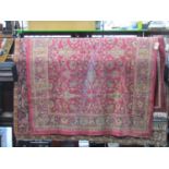 Belgian carpet in the Persian style with red ground, repeating floral detail and within running