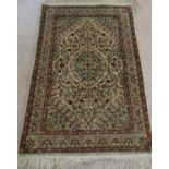 A Persian wall hanging/small rug, the central medallion upon a pale cream field with floral detail