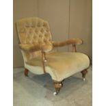 A Victorian drawing room/library chair with deep buttoned back and wide seat, with cushioned arms