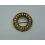 Circular yellow metal seed pearl brooch with rope twist border, 5.4g