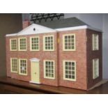 A Georgian style dolls house with mock red brick facade, together with a quantity of furniture