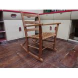 Arts and crafts type pitch pine rocking chair with straw woven seat