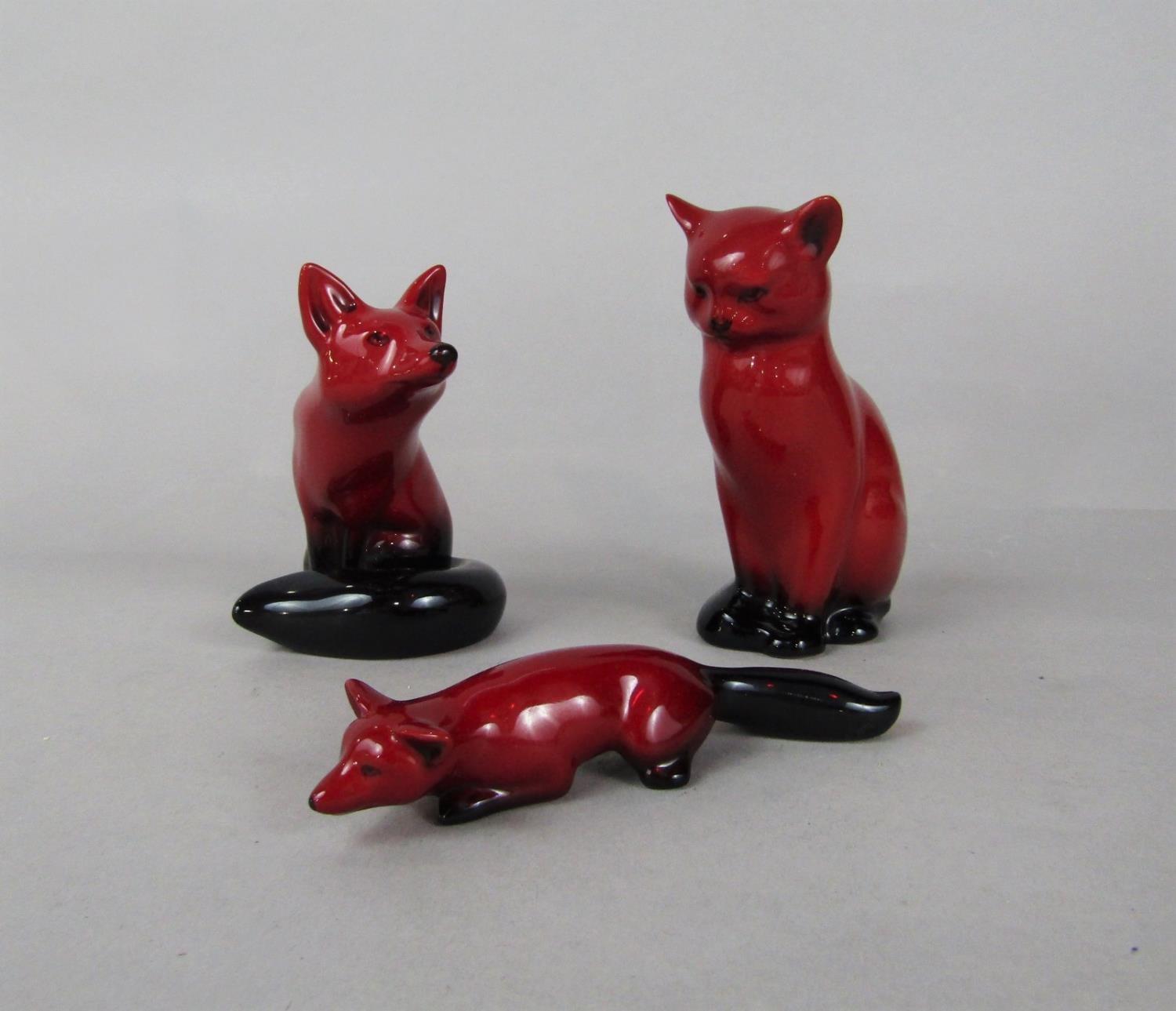Three Royal Doulton Flambé figures of a seated fox, a stalking fox and a seated cat (3)