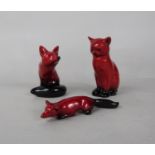 Three Royal Doulton Flambé figures of a seated fox, a stalking fox and a seated cat (3)