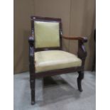A Regency mahogany elbow chair with scrolled arms and short sabre forelegs, with carved anthemion