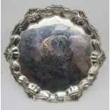 A Georgian silver salver, the raised borders with C scroll and shell detail, raised on three pad