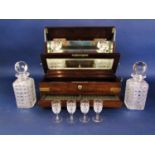 A good quality early 20th century oak tantalus, fitted with four cut glass decanters and stoppers,