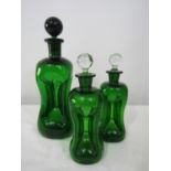 Pair of Scandinavian dimpled green glass lidded decanters, 21cm high, together with a further larger