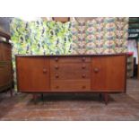 A Younger teak bow-fronted long sideboard, with central rank of four graduated doors, flanked by