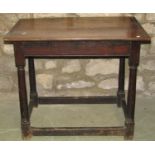 An antique oak country made side table, the rectangular boarded top raised on turned gun barrel