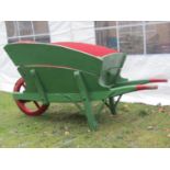 An antique traditional green and red painted wooden wheelbarrow, with chamfered detail, removable