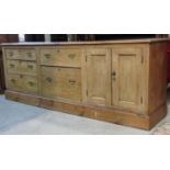 A substantial stripped pine farmhouse kitchen dresser fitted with an arrangement of five drawers
