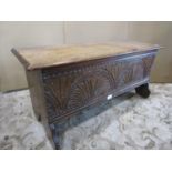 A small antique oak six plank coffer with hinged lid and carved front elevation, 90 cm wide x 36