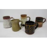 A collection of five studio pottery tankards all with monogram signatures, the largest 15cm tall (5)