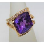 Amethyst and diamond crossover type ring, unmarked, tests as 18ct gold, size O, 14.6g