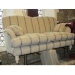 A contemporary two seat sofa with striped detail raised on turned supports, 170 cm wide approx