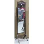 A Edwardian mahagany cheval mirror raised on swept supports