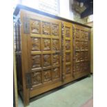 A medium oak side cupboard of continental origin enclosed by a pair of doors with portrait panels