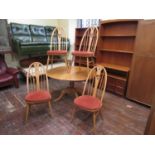 Ercol light elm extending kitchen table, upon a turned baluster column and four splayed legs,