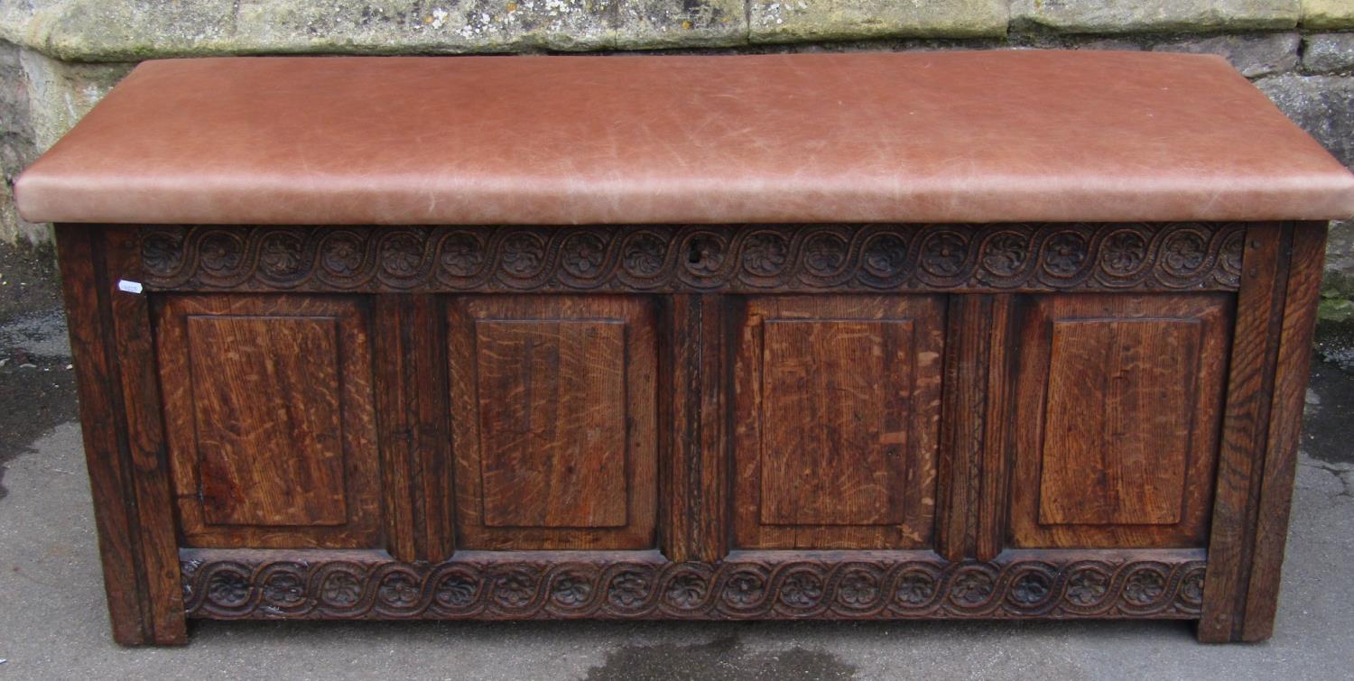 An 18th century oak coffer with panelled frame, moulded styles and carved foliate detail beneath a