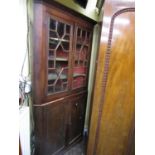 19th century mahogany freestanding corner cupboard, the lower section enclosed by two panelled