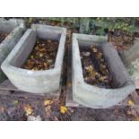 A pair of weathered natural stone troughs of rectangular form with single D ends and notched