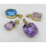 Four 9ct faceted gem set pendants; three amethyst and one blue topaz example (4)