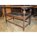 A Victorian carved oak monks bench/table with dowled hinged top and carved foliate detail, raised on