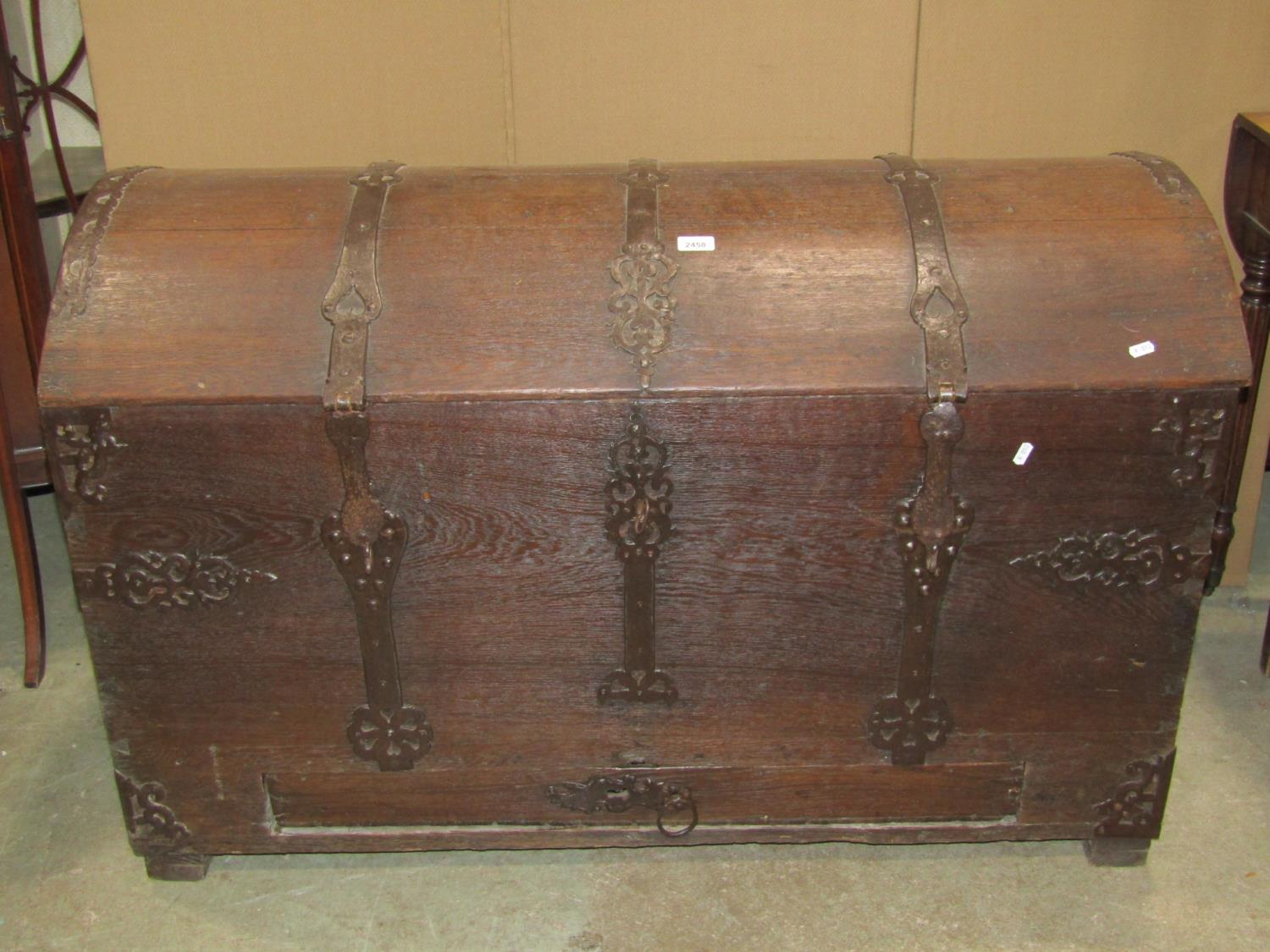 An 18th century oak domed top trunk/coffer with exposed strap work hinges, lasps and fittings and