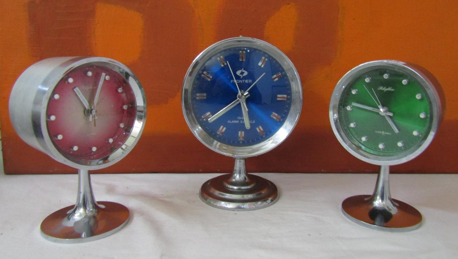 Matched pair of Rhythmn alarm clocks on chrome tulip bases together with a similar Frontier clock (