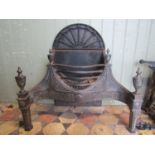 An Adam style cast iron and steel fire grate with serpentine front, bowed basket and decorative