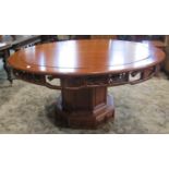 A good quality Chinese hardwood dining table, the circular top over a carved and pierced frieze
