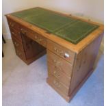 A contemporary stripped and waxed pine pedestal writing desk of nine drawers, with brass swan neck